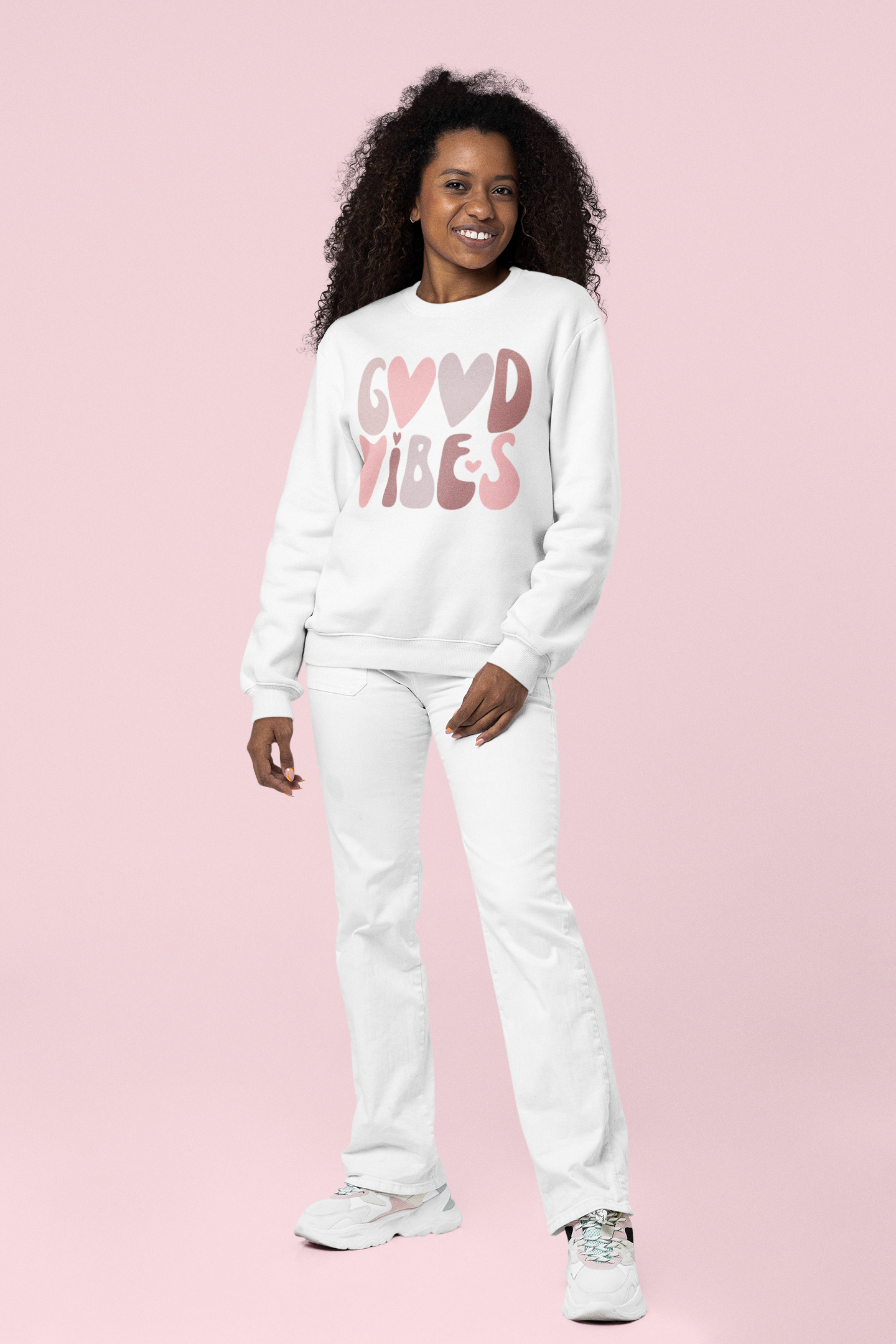 A woman wearing a white Sharp Tact Kreativ "Good Vibes" sweatshirt.