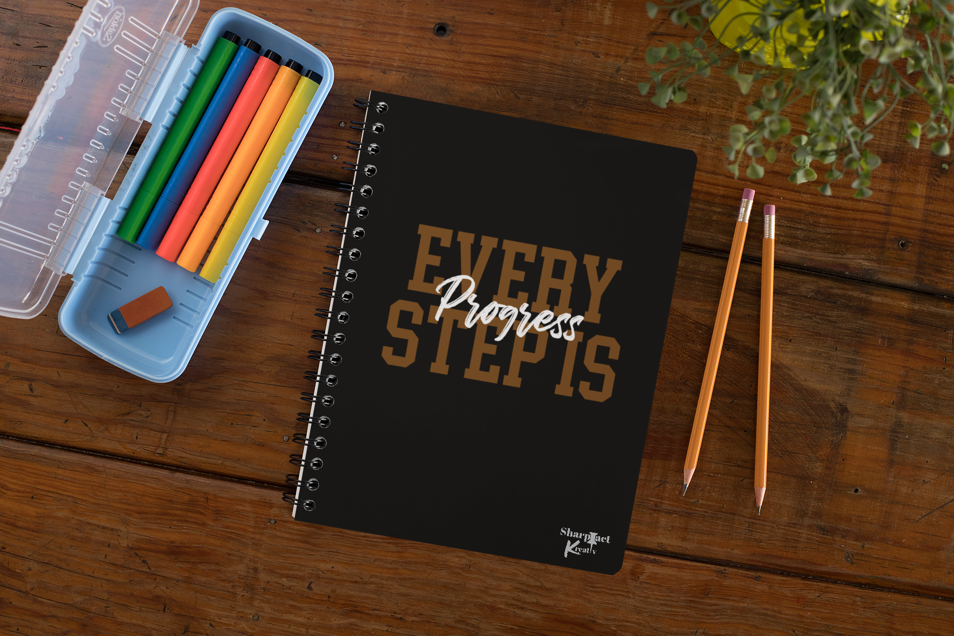 Every Step is Progress Notebook is a Sharp Tact Kreativ | Tees & Gifts with Encouraging Messages to Brighten Your Day with a Bit of Wit notebook on a wooden table.