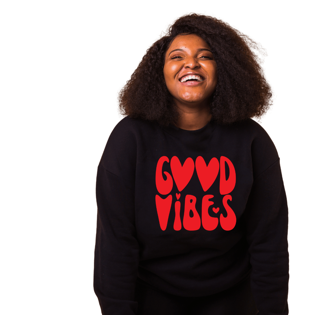 A black woman wearing a Sharp Tact Kreativ crewneck sweatshirt that says Good Vibes Red Sweatshirt, made from cotton and polyester fleece knit.