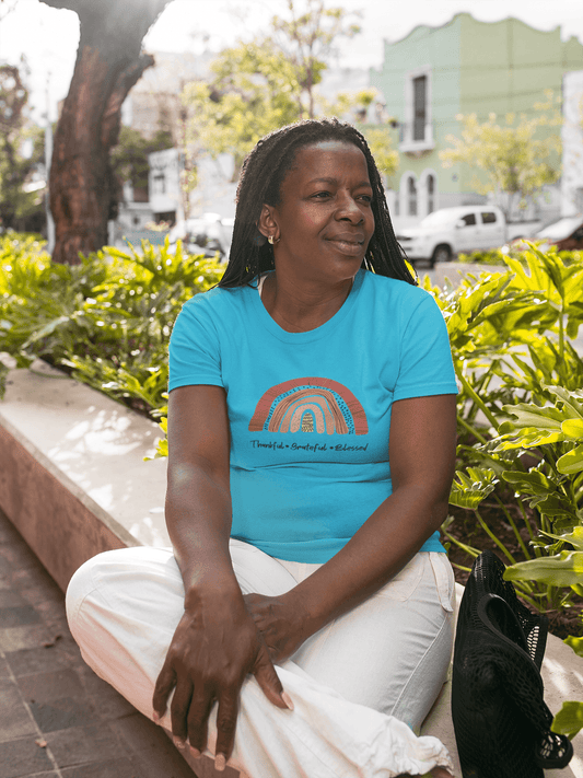 A woman sitting on a bench, grateful and comfortable in her Thankful, Grateful, Blessed Tee by Sharp Tact Kreativ | Tees & Gifts with Encouraging Messages to Brighten Your Day with a Bit of Wit.