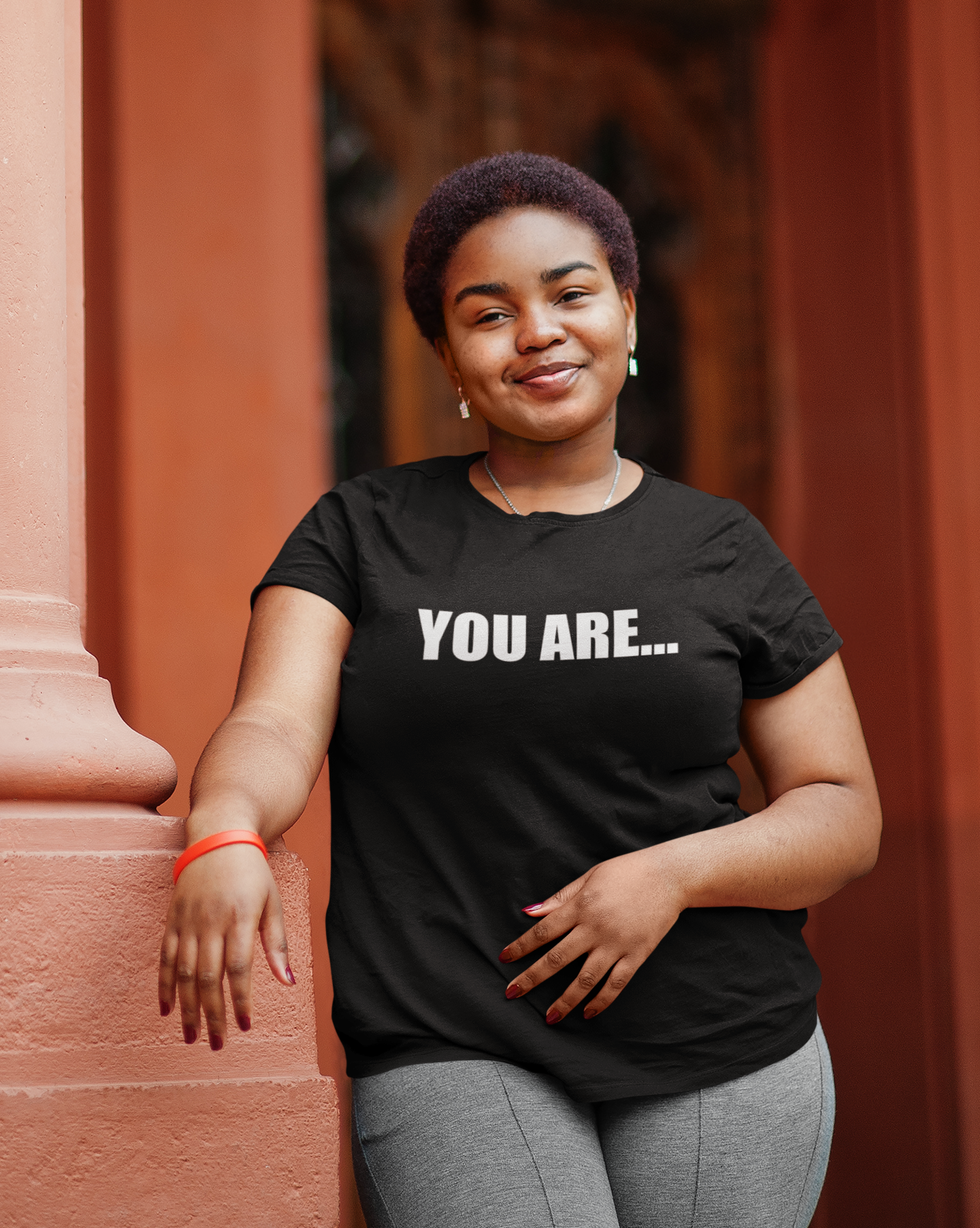 A woman wearing a black You Are... Tee by Sharp Tact Kreativ | Tees & Gifts with Encouraging Messages to Brighten Your Day with a Bit of Wit t - shirt.