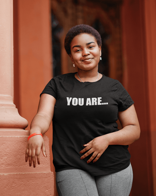 A woman wearing a black You Are... Tee by Sharp Tact Kreativ | Tees & Gifts with Encouraging Messages to Brighten Your Day with a Bit of Wit t - shirt.