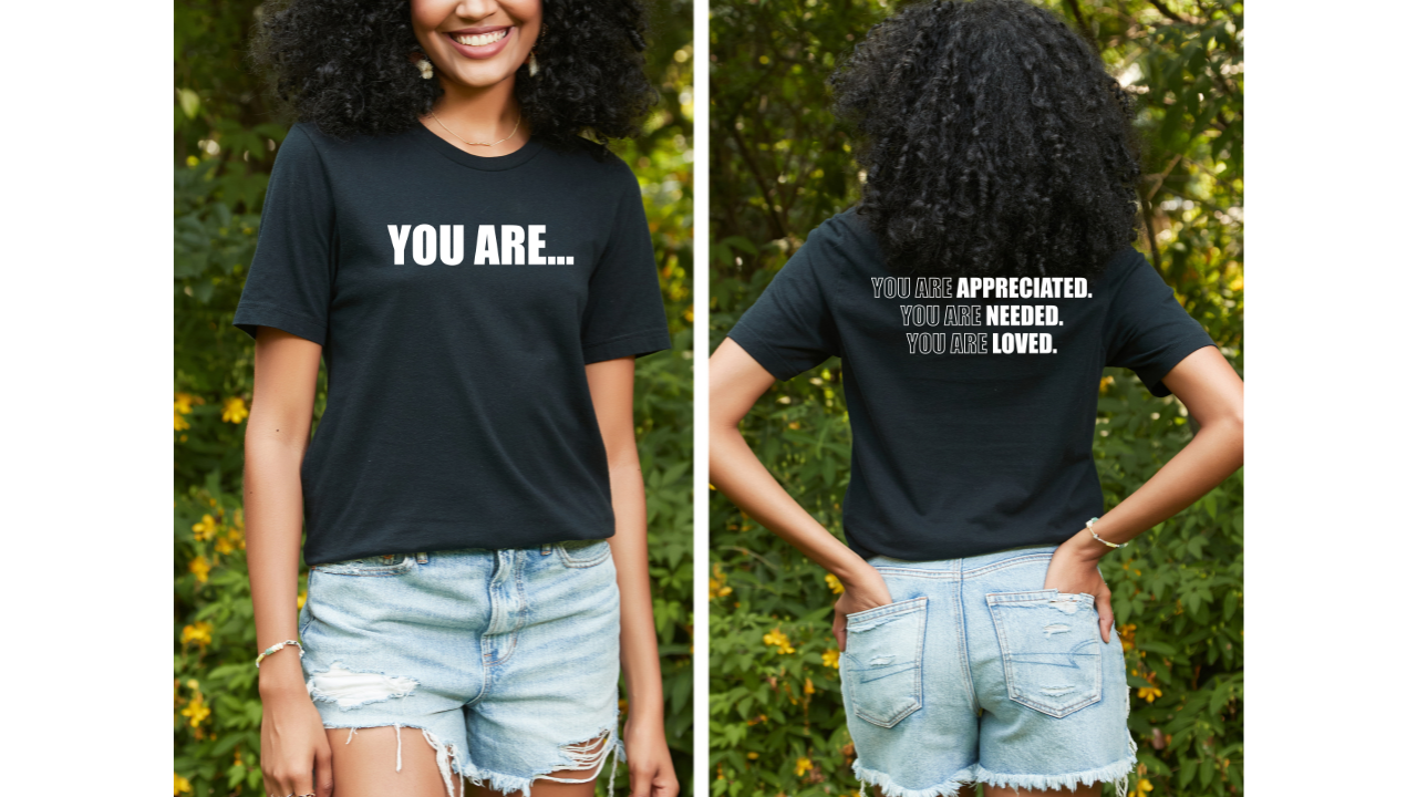 A woman wearing a black You Are... Tee from Sharp Tact Kreativ | Tees & Gifts with Encouraging Messages to Brighten Your Day with a Bit of Wit t-shirt.
