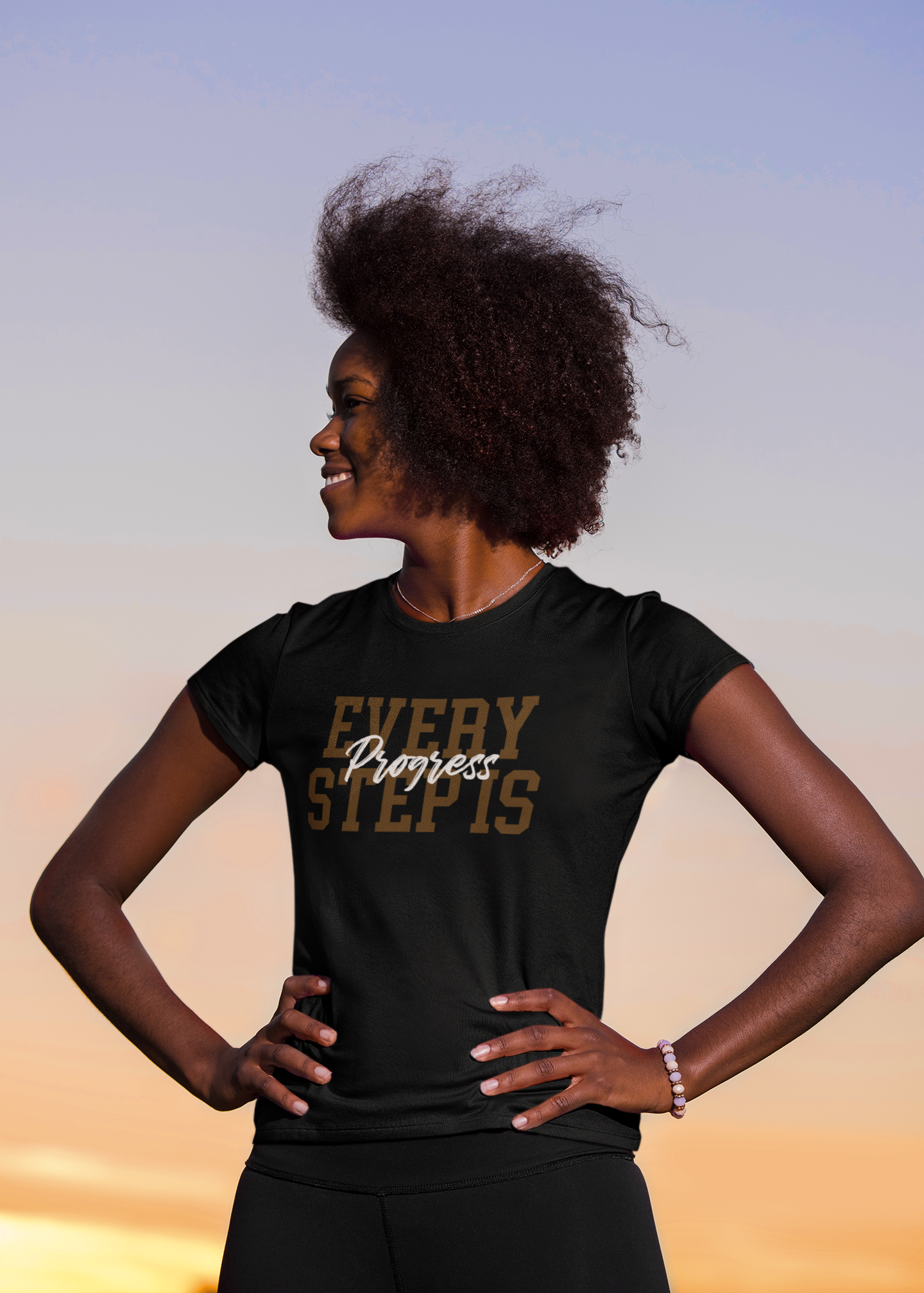 A woman wearing a black t-shirt from the Sharp Tact Kreativ | Tees & Gifts with Encouraging Messages to Brighten Your Day with a Bit of Wit brand that says Every Step is Progress Bundle.