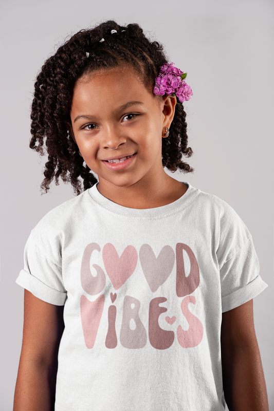 A little girl wearing a Good Vibes Tee (Youth Size) by Sharp Tact Kreativ.