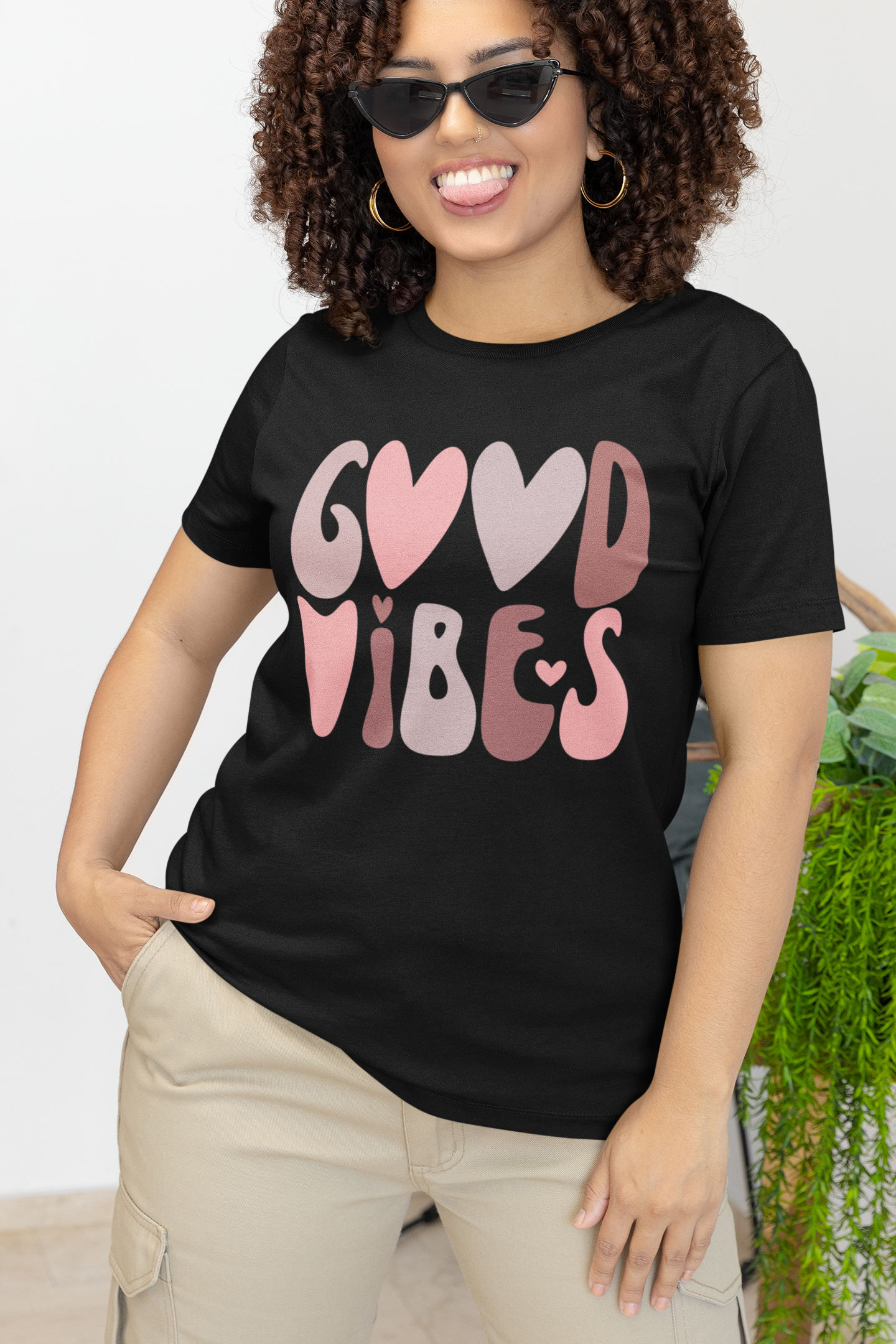 A woman wearing a Sharp Tact Kreativ | Tees & Gifts with Encouraging Messages to Brighten Your Day with a Bit of Wit Good Vibes Tee.